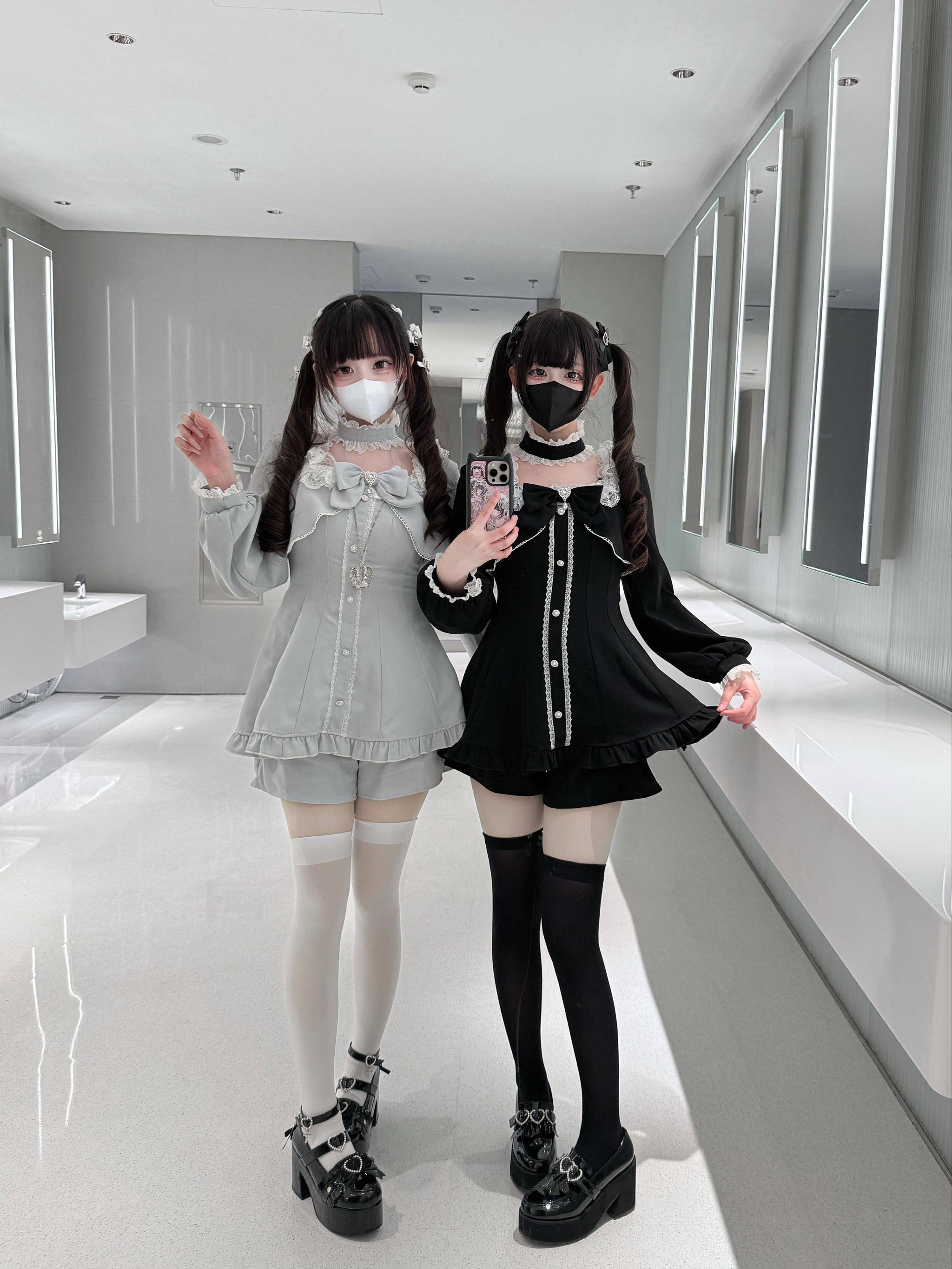 Jirai Kei gothic dress and pocketed shorts set in black and gray variants, front mirror view with ruffled hems on two female models