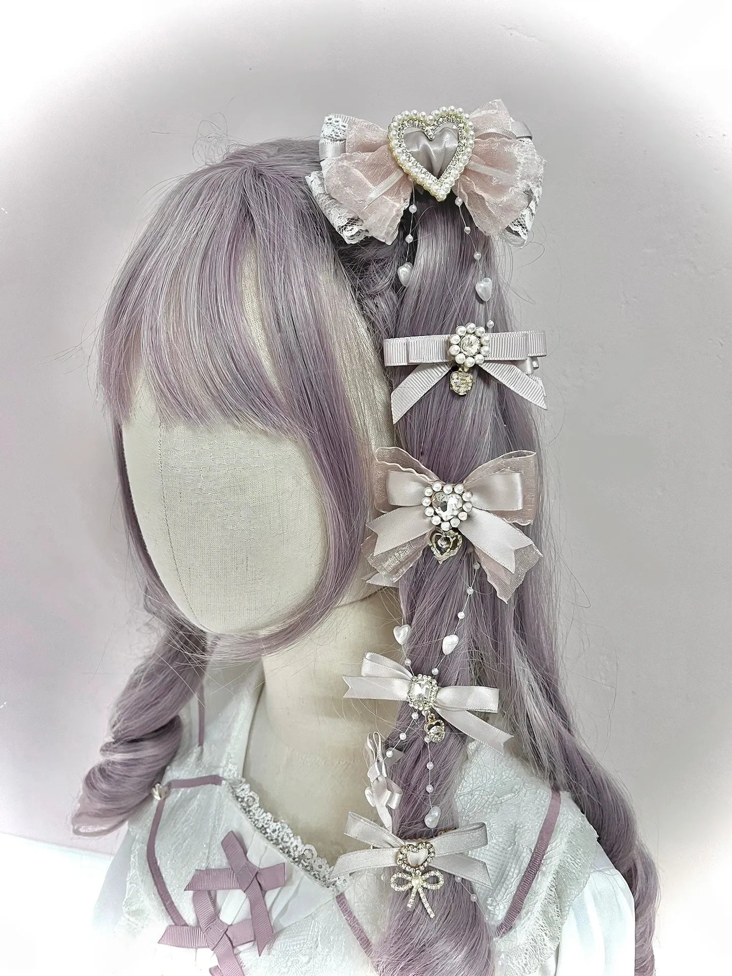 Mixed style Jirai Kei bow hair clips featuring lace and heart decorations with dangling pearl accents on mannequin head right rear view angle