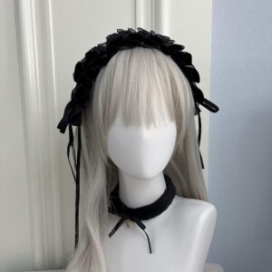 Black pleated satin lace Gothic Lolita headband with long ribbon tassels and matching choker, front three-quarter view on grey twin-tail mannequin