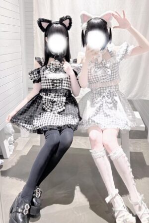 Girl wearing black gingham jirai kei plaid outfit with cat ears sitting outdoors showing side profile with thigh-high socks and platform shoes