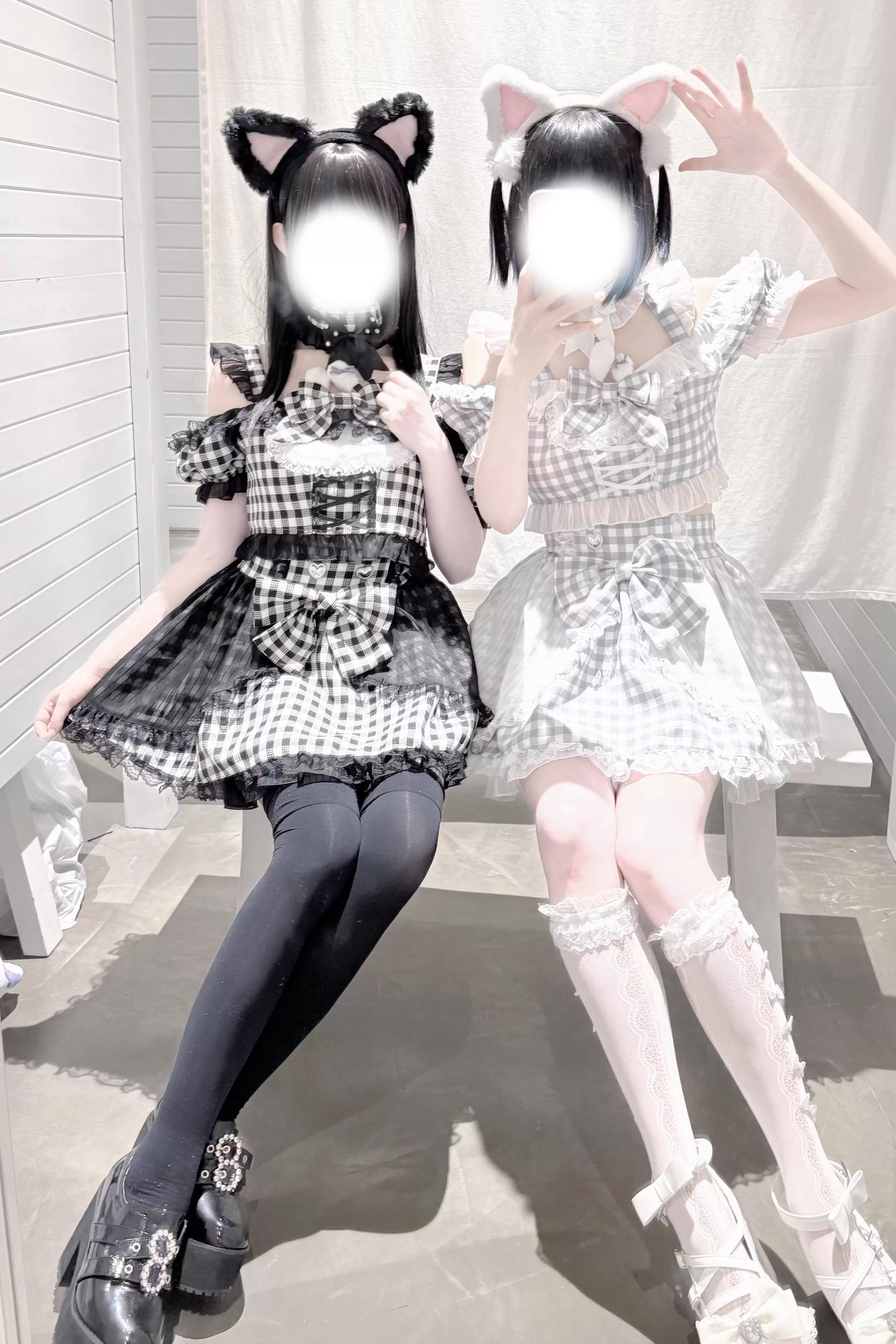 Girl wearing black gingham jirai kei plaid outfit with cat ears sitting outdoors showing side profile with thigh-high socks and platform shoes