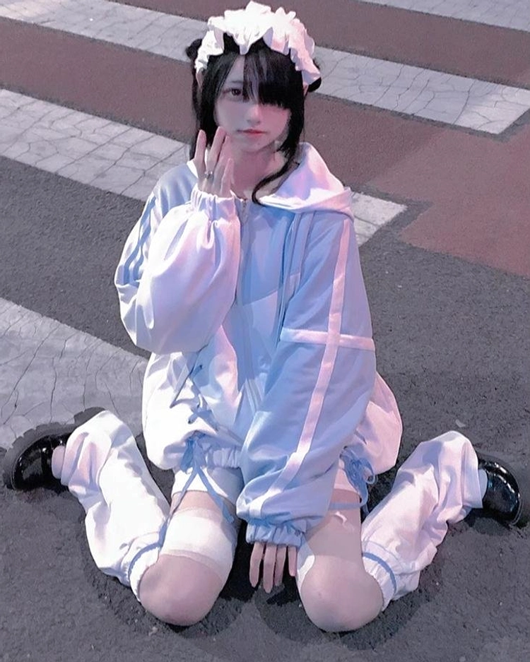 Baby blue-white sport hoodie set Jirai Kei style with contrast color panels, oversized loose sleeves, and matching leg warmers on kneeling model outdoors