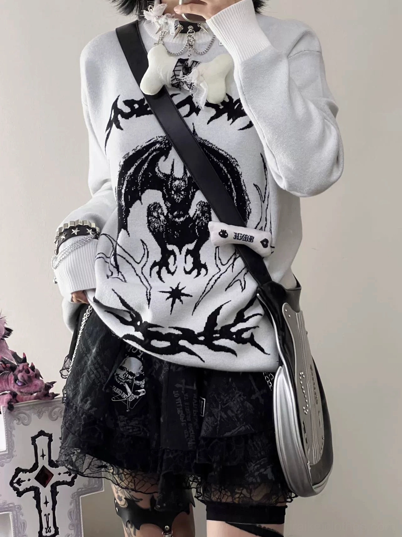 White bat embroidered sweater side profile close-up with black lace skirt plush brooch and cross shoulder bag