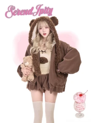 Front full-body view of bear ear Jirai Kei fleece loungewear set featuring brown fuzzy hoodie with bear ears, cream camisole with bear embellishment, brown bubble shorts, model holding plush teddy against pink heart background