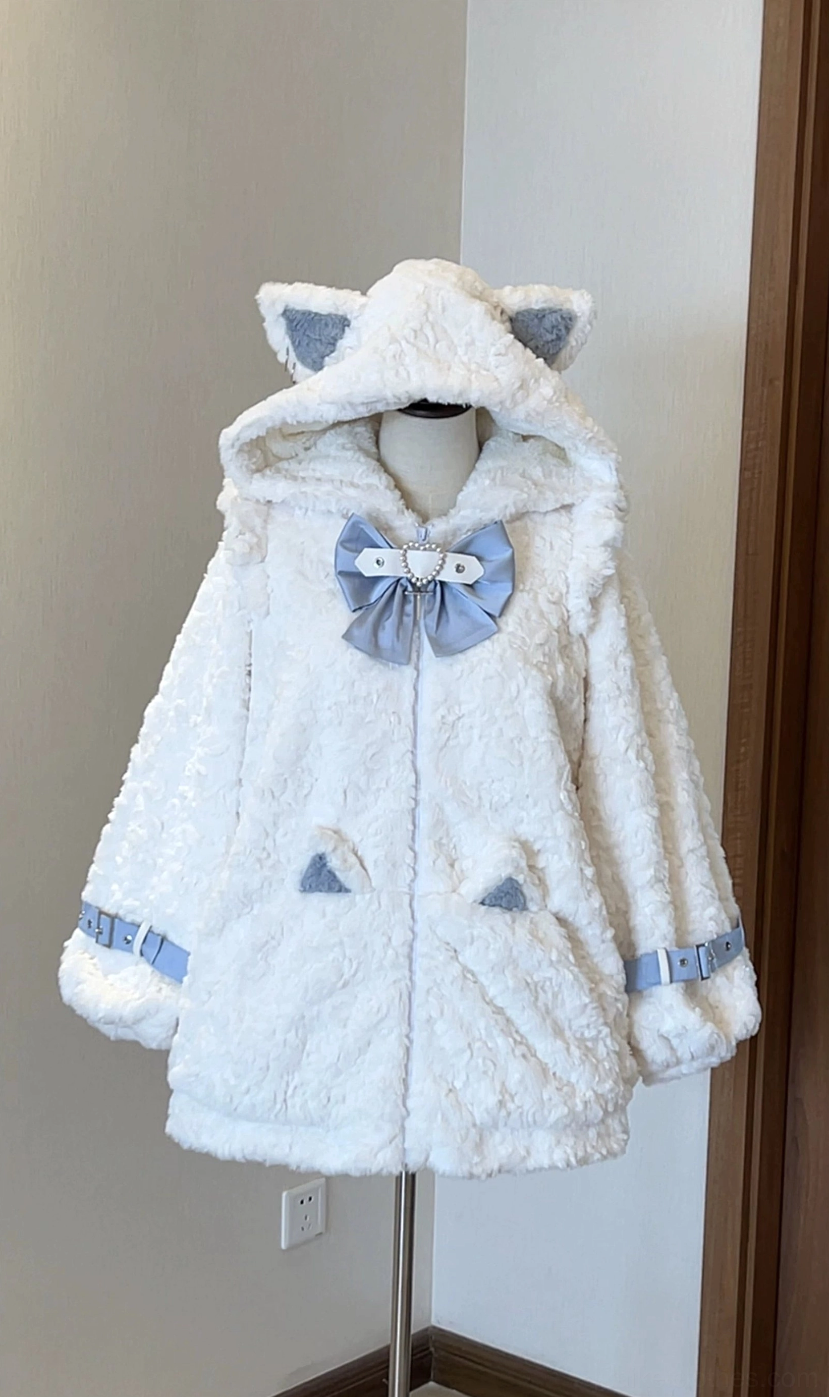 Light beige and blue Jirai Kei cat ear hood fleece coat, three-quarter angle showing blue bow, blue buckle cuff details, and cat ear pocket embellishments