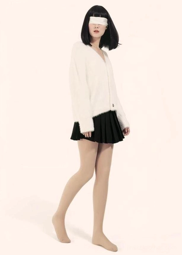 Side profile full-body view of model in beige velvet tights with white cardigan and black mini skirt - soft pink background showing jirai kei styling aesthetic
