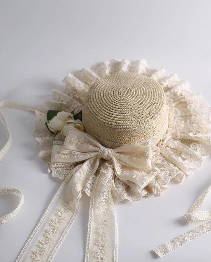 Beige country lolita straw sunhat flat lay close-up front view with delicate lace brim satin bow and embroidered ribbon sashes