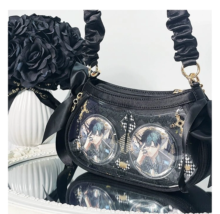 Black anime ita bag featuring ruched satin straps, elegant satin bows, and dual clear badge windows with gold hardware, photographed from overhead front perspective with black artificial roses background