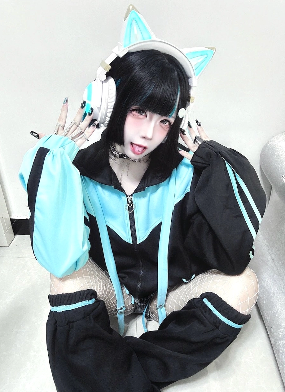 Black-blue color block Tenshi Kaiwai sport hoodie set with cat-ear headphones, contrast cuffs, and cross-lacing on model with short hair indoors