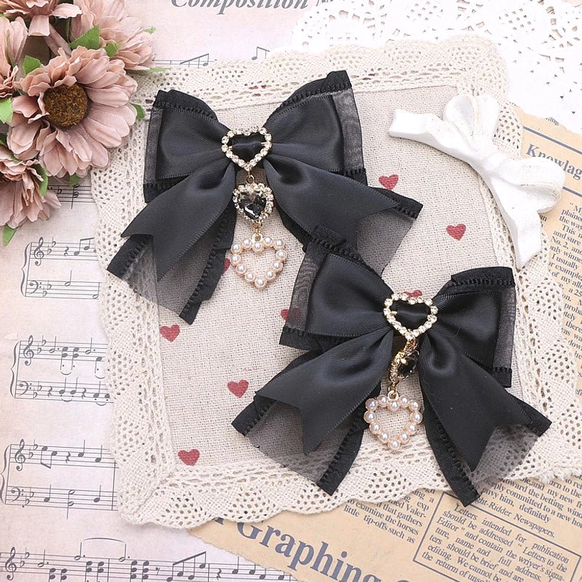 Black bow hair clip with heart rhinestone pendant shown on wig mannequin - bold Jirai Kei styling option
