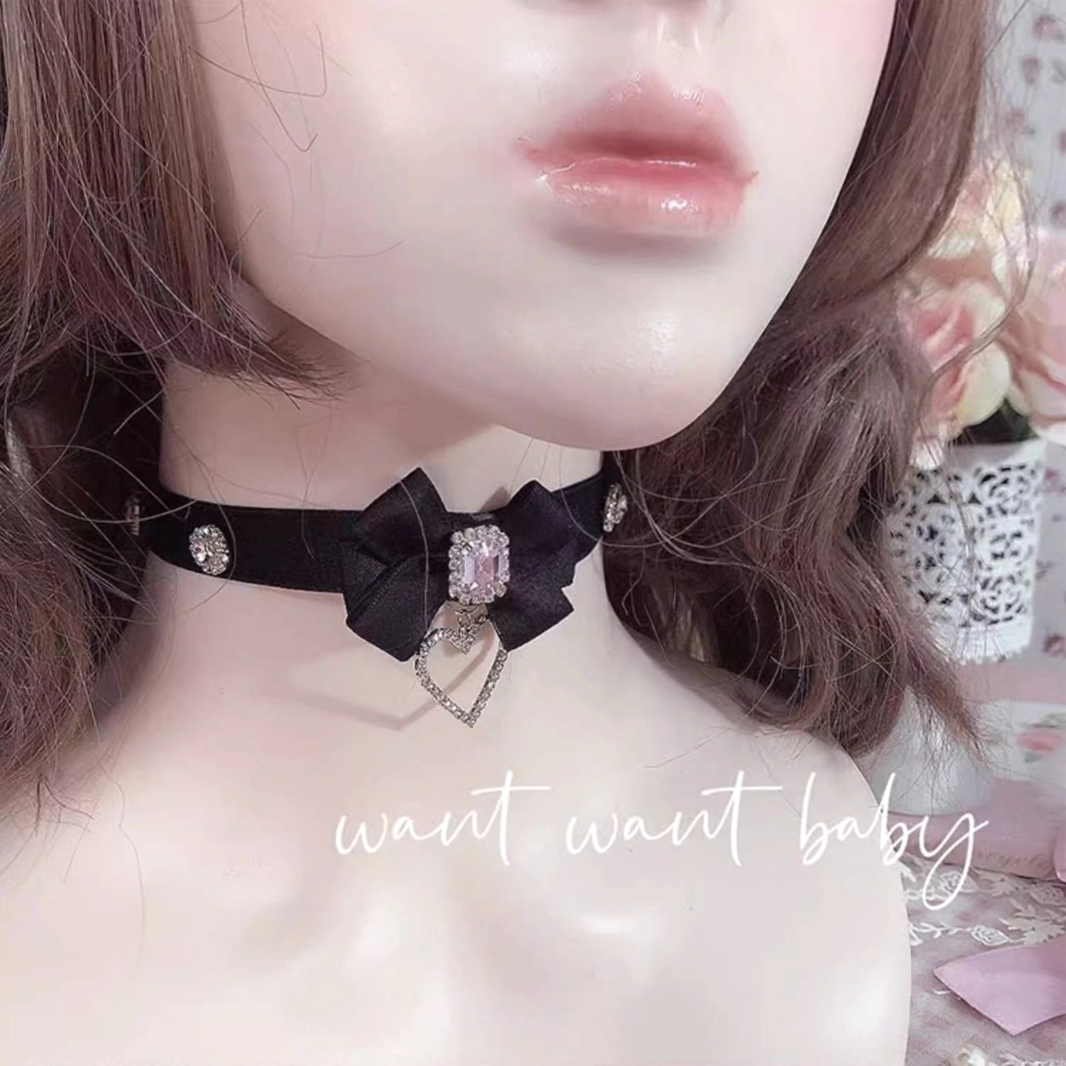 Black satin bow rhinestone choker necklace worn on BJD doll model showing how choker sits on neck with central gem bow and heart-shaped rhinestone dangle