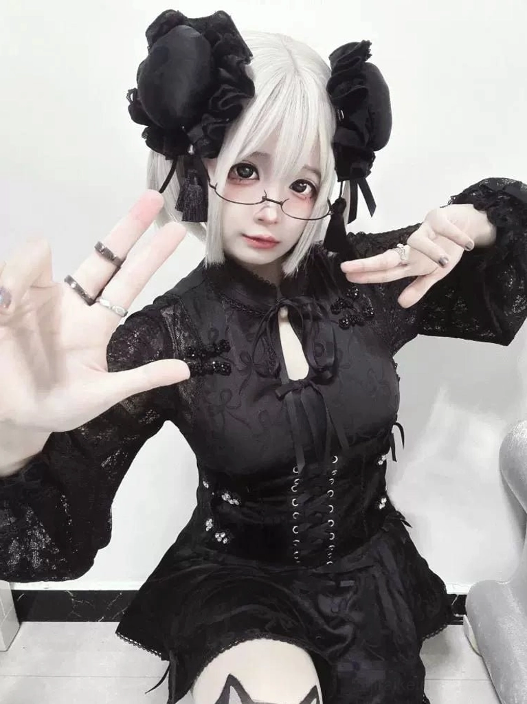 Black lace cheongsam dress set with long sleeves corset waist and lace detailing modeled indoors showing glasses and black hair ornaments accent pieces
