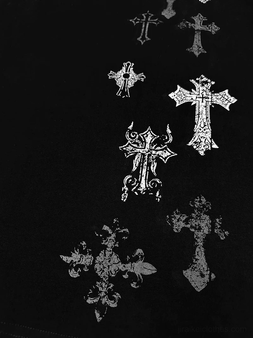 Close-up flat lay of black cross print t-shirt showing various silver vintage cross print details on black fabric, detailed product photography