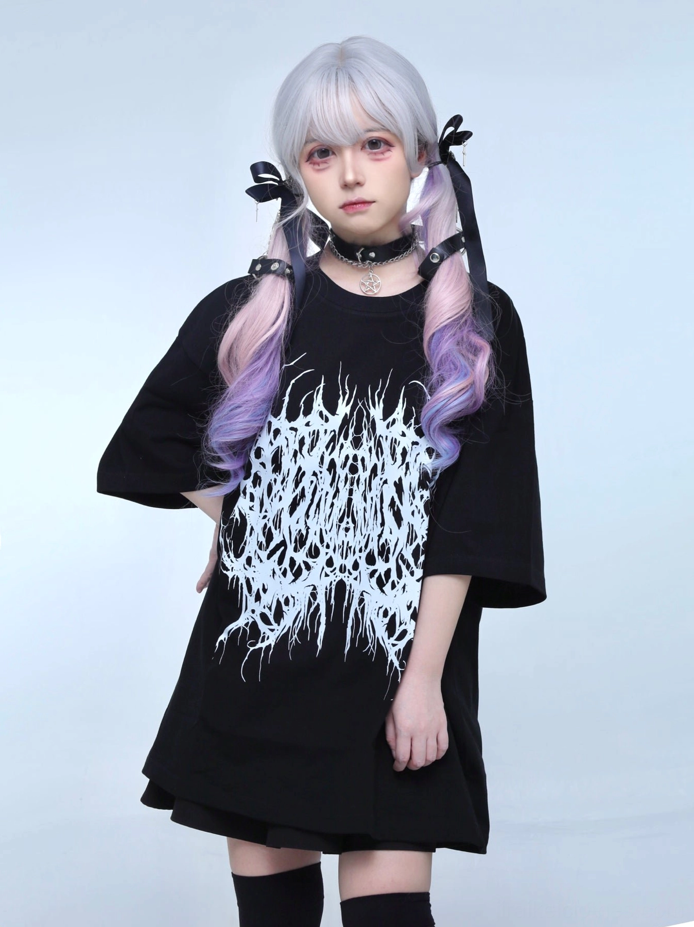 Black oversized gothic Jirai Kei t-shirt with brutal white metal print front view three-quarter angle twin-tail model choker black thigh highs
