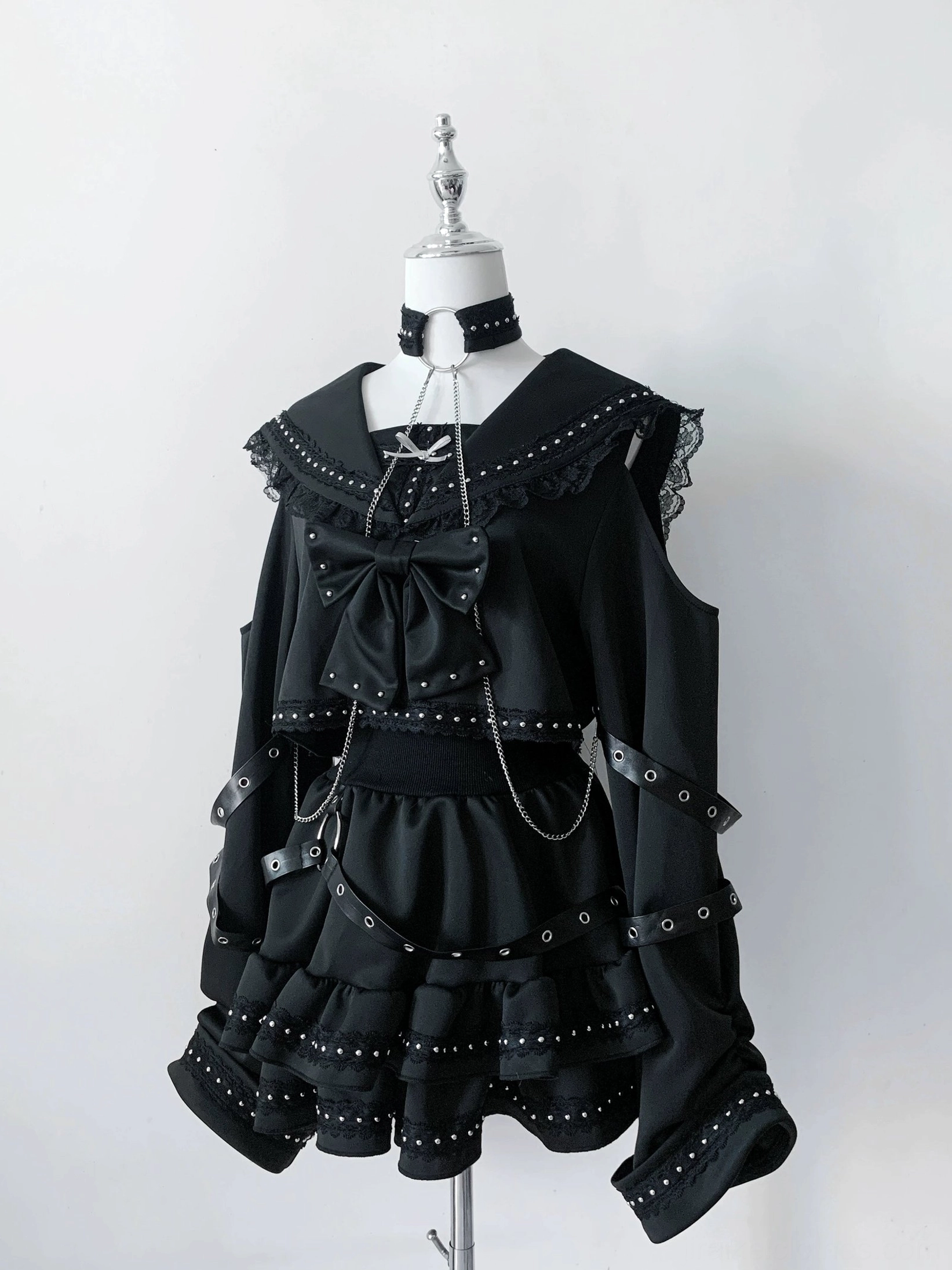 Single black gothic two-piece sailor set front view on display mannequin with ruffled hem bow and chain accent details