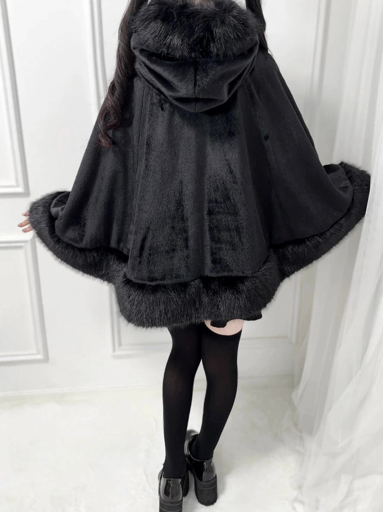 Black hooded winter cape coat back view Jirai Kei style with faux fur hem trim and attached hood