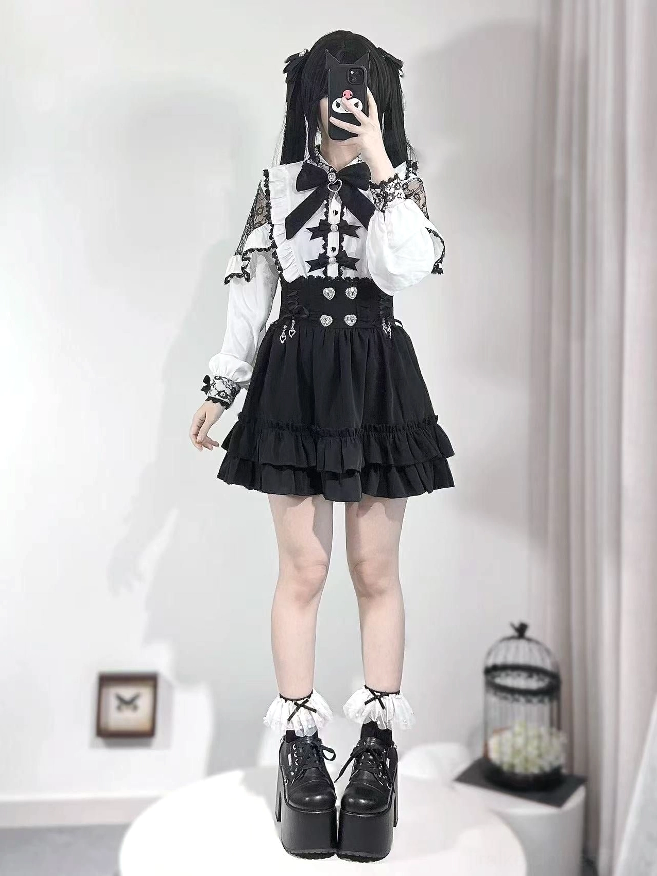 Black Jirai Kei A-line skirt with double flounce ruffle hem and heart-shaped rhinestone waistband, worn by model with twin tails in studio setting, showcasing full front view of lace sleeve details