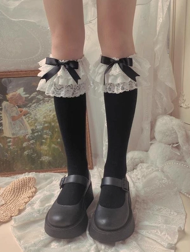 Black Jirai Kei bow mid-calf socks with layered white lace trim black satin bow black platform Mary Jane shoes vintage painting plush backdrop three-quarter