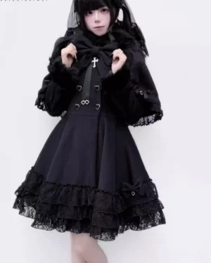 Black Jirai Kei detachable cape winter coat with layered lace trim and fur collar, front upper body view showing heart-shaped buttons and cross bow ornament