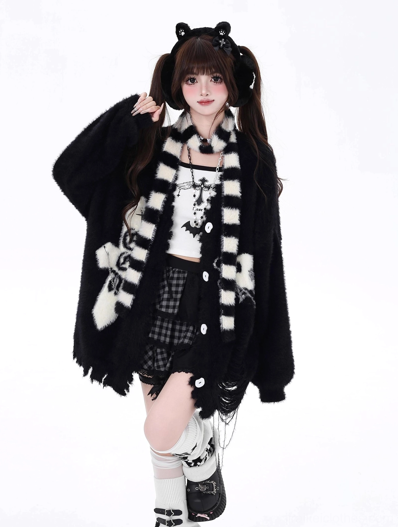 Black Jirai Kei oversized cardigan half-body view showing distressed hem, cross and skull prints, paired with black-white striped scarf, cat-ear headband styling