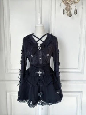 Black Jirai Kei cardigan and tulle skirt two-piece set with heart-shaped buttons and cross bow decoration displayed on dress mannequin front view gothic lolita style