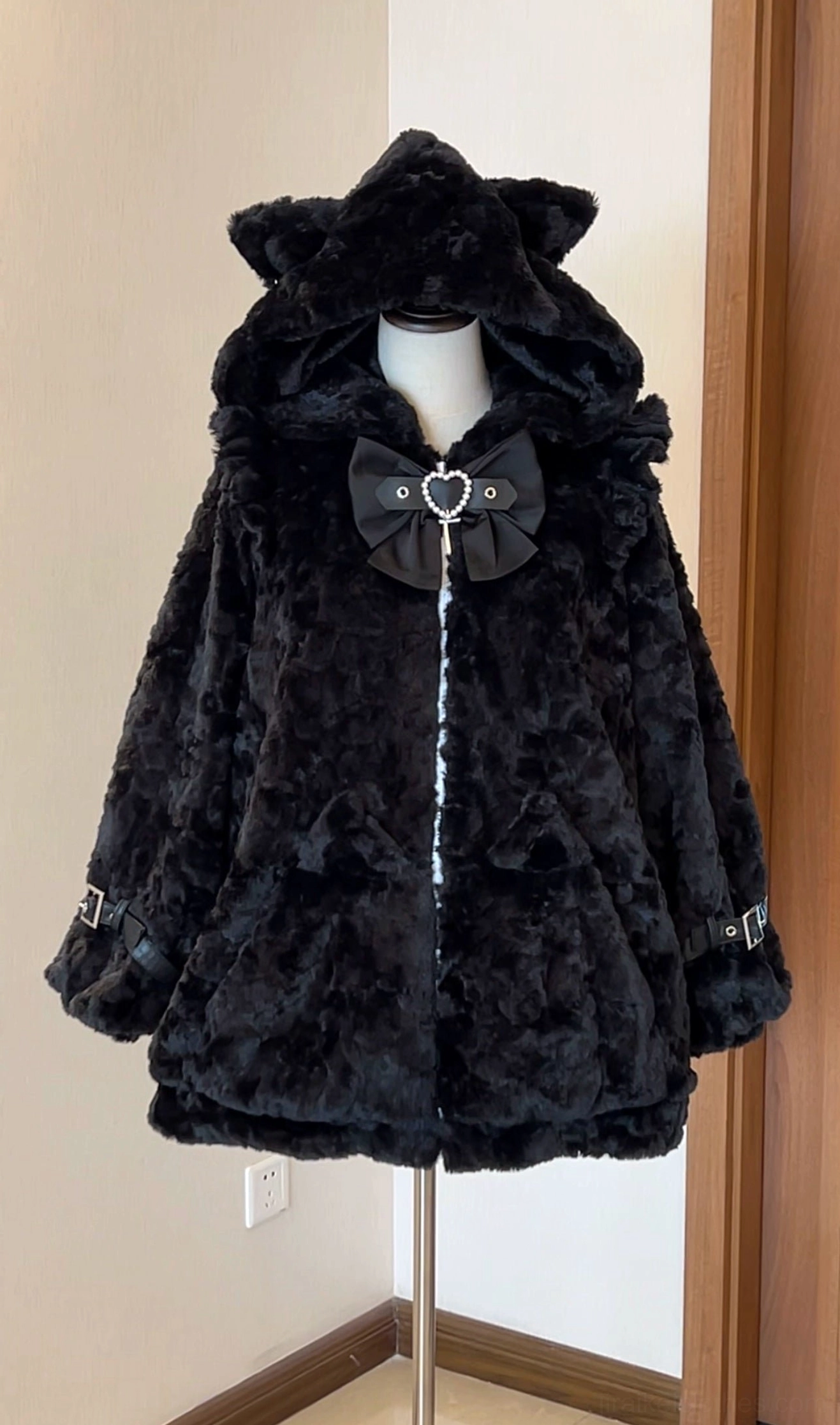 Black plush fleece Jirai Kei cat ear hood coat with black heart bow decoration and front zipper closure, direct front view on mannequin