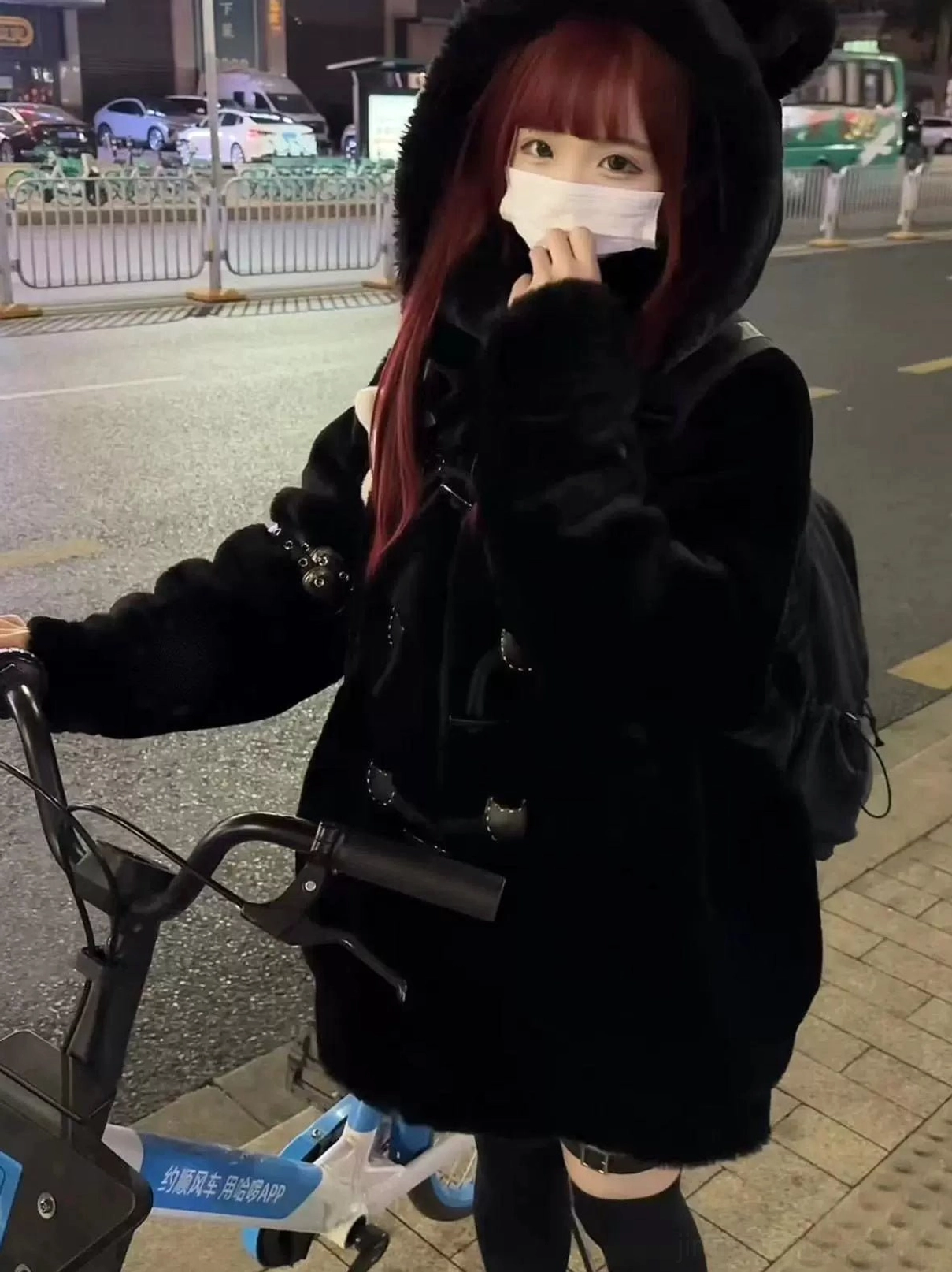 Black plush cat ear hooded fuzzy winter coat side-front view red-haired model shared bicycle street riding horn closures