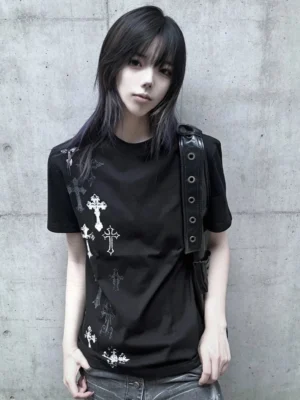 Black Jirai Kei cross print t-shirt with silver multiple style crosses on front, worn by female model against concrete wall, structured shoulders and crew neck design visible