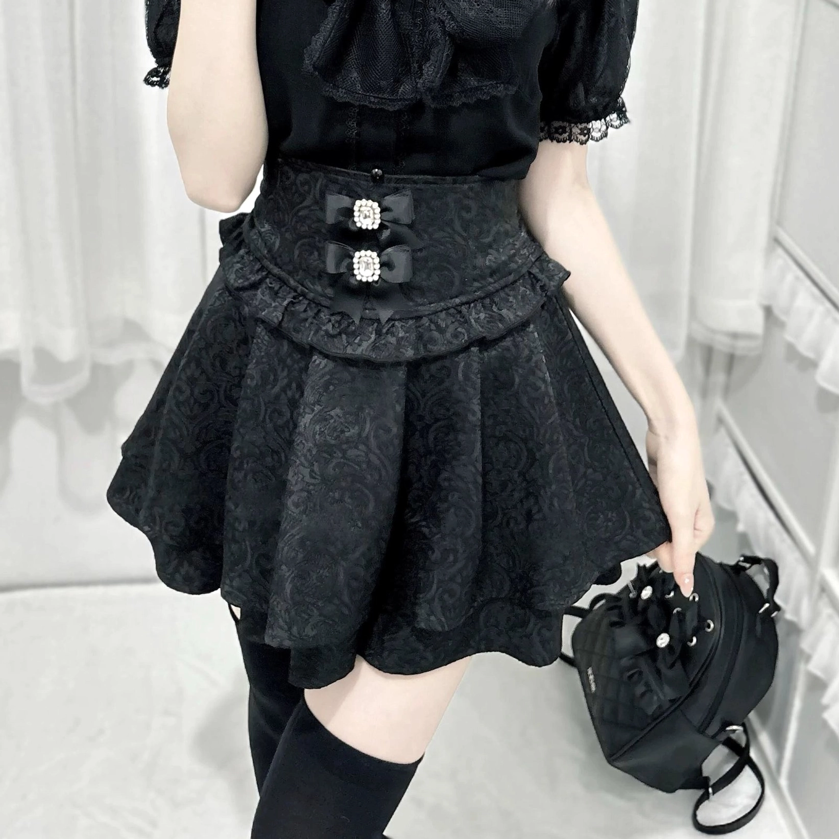 Black Jirai Kei double-ruffle skirt close-up rear three-quarter view crystal waist buckles jacquard detail