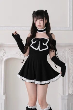 Black off-shoulder ruffled Jirai Kei mini dress with white bow choker and detachable arm sleeves worn by model, front full view vintage fireplace setting