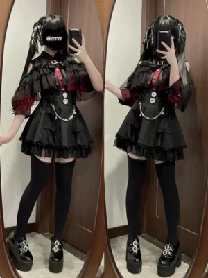 High-waisted black Jirai Kei skirt with layered lace and rhinestone chain worn by twin gothic models in mirror selfie, full-length view showcasing ruffled hem and silver decorations
