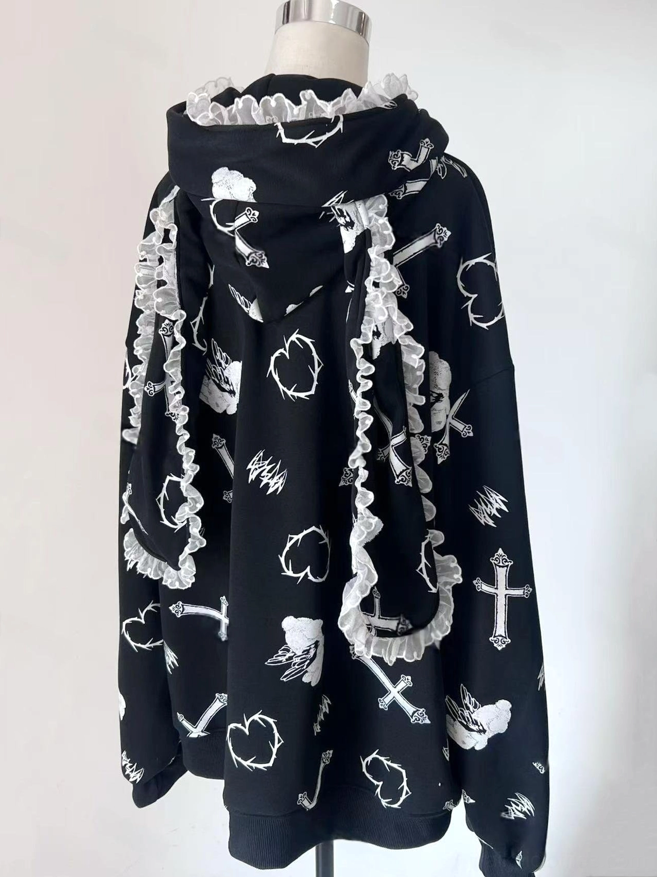 Black Jirai Kei hoodie jacket back product view on white studio background, featuring lace-trimmed hood and heart and cross print anime artwork
