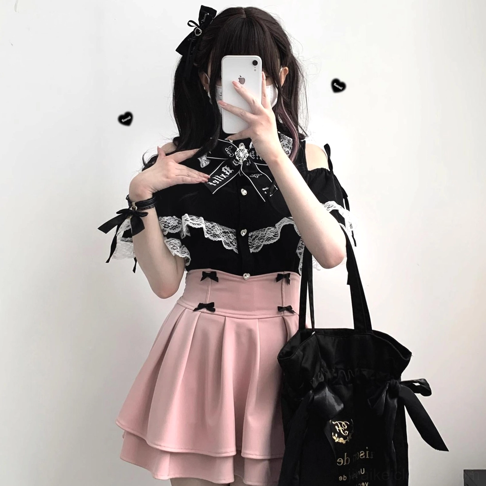 Black Jirai Kei lace off-shoulder blouse styled with pink pleated skirt on model in indoor studio selfie showing off-shoulder design