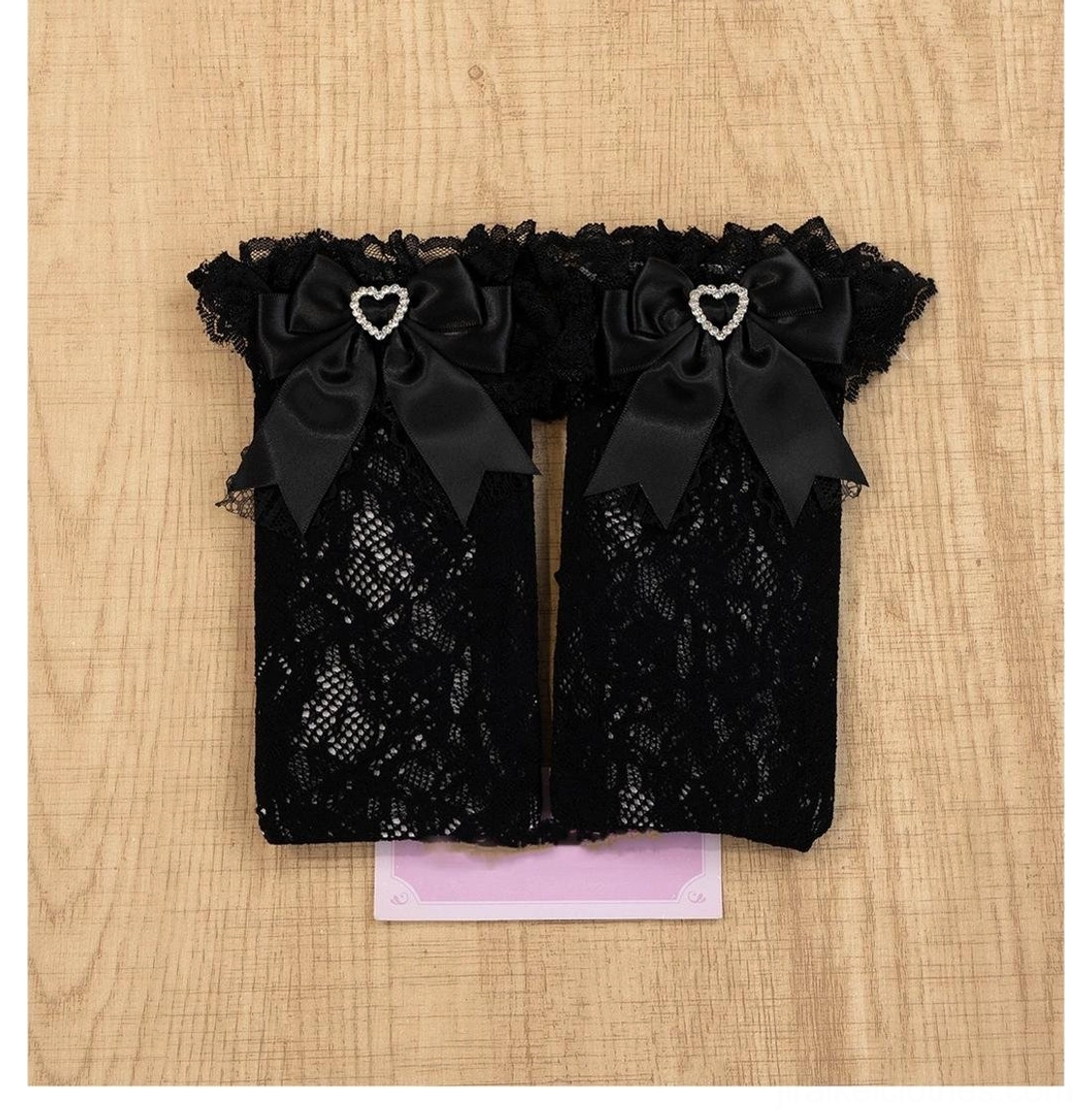 Black jirai kei lace ankle socks with heart-shaped rhinestones and decorative satin bow embellishments in classic color