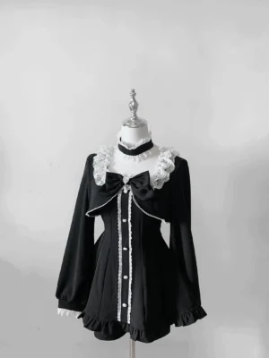 Black gothic Jirai Kei long-sleeve dress with removable chest bow, lace collar, and pearl button trim on mannequin flat display