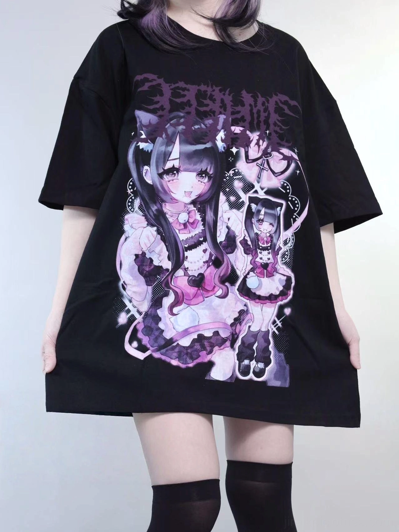 Black oversized jirai kei drop shoulder maid graphic t-shirt with purple and pink gothic print, worn by model with black thigh-high socks, front view studio shot