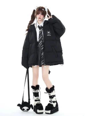 Black oversized Jirai Kei winter puffer jacket front view with chest cartoon logo and detachable devil bag on twin-tail school uniform model