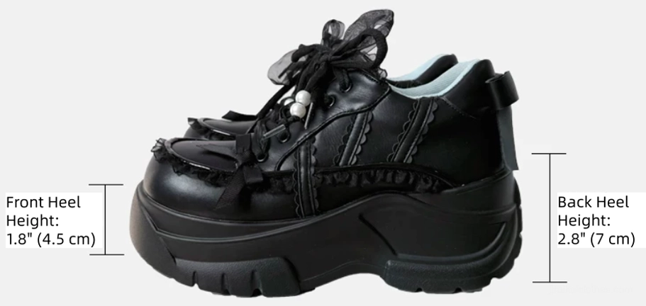 Single black Jirai Kei platform shoe side three-quarter view on light gray background showing marked heel heights rugged chunky sole and decorations