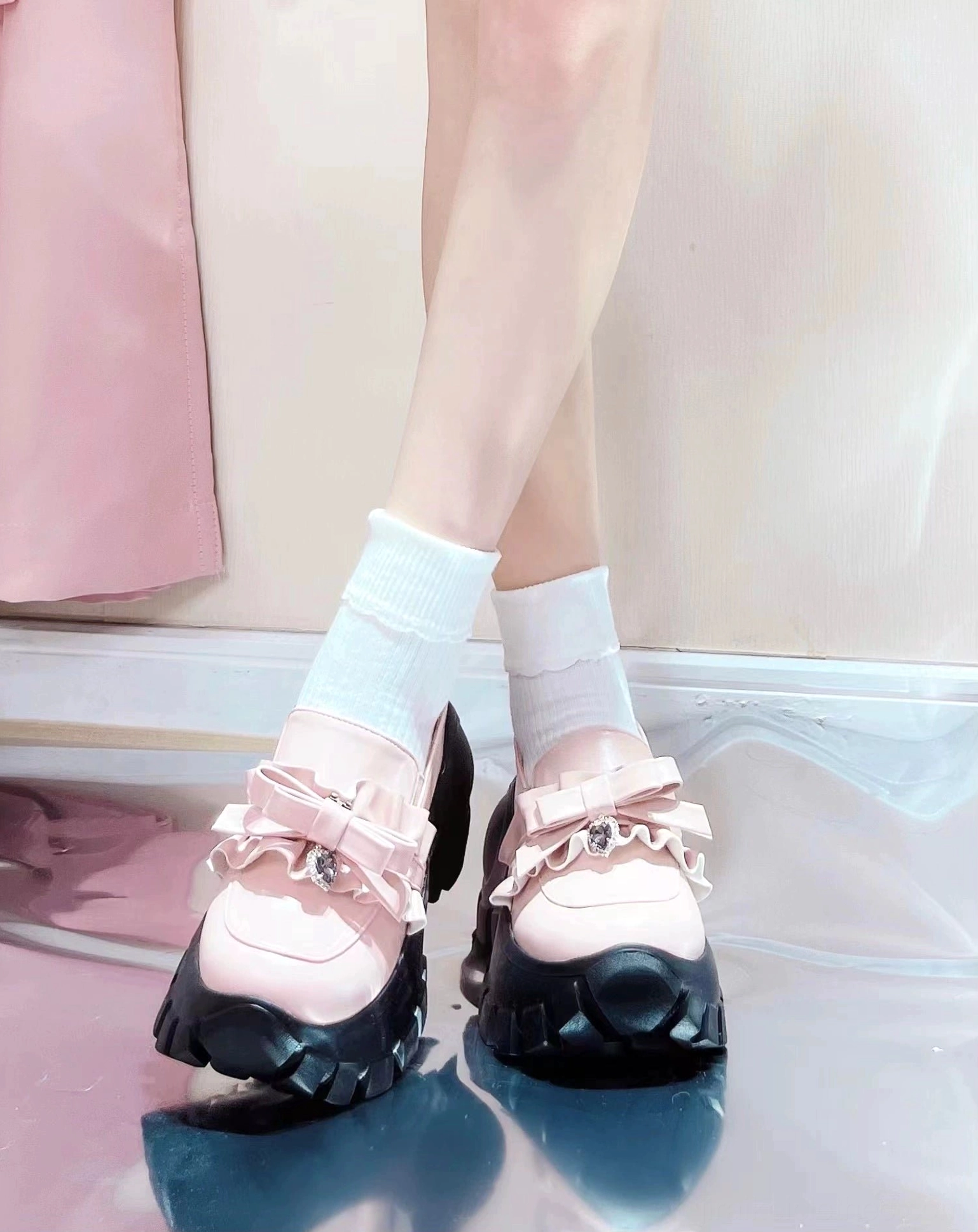 Black JK platform shoes with heart gem rhinestone bow and thick lug sole paired with cross-print sheer stockings in dark studio photography