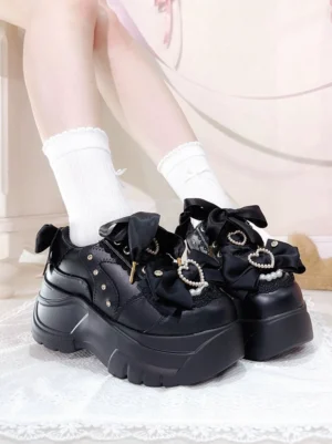 Black Jirai Kei platform shoes with satin bow and heart rhinestone decorations, chunky serrated sole, model wearing white crew socks in sweet bedroom aesthetic