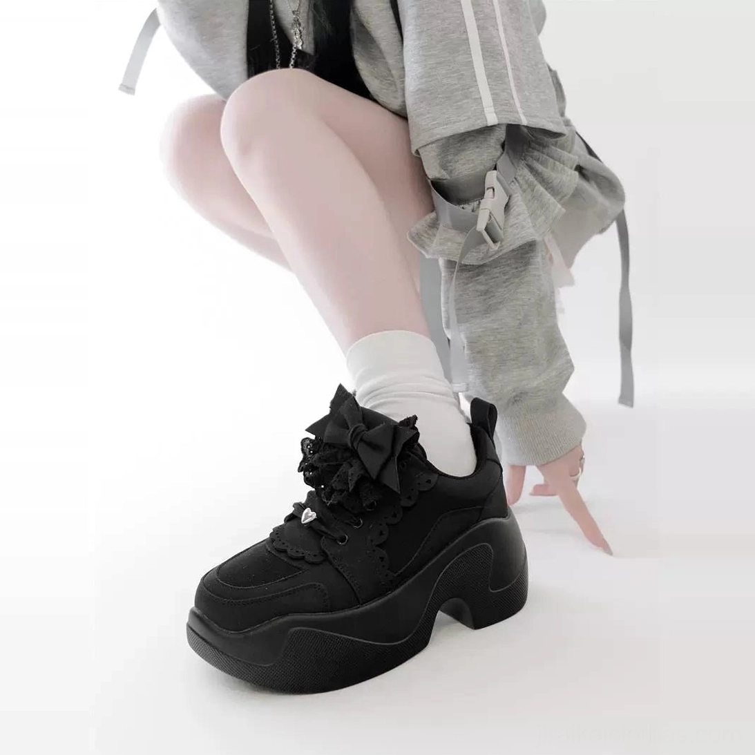Black Jirai Kei platform sneakers low front-side single foot view model gray cropped jacket white socks matte black thick platform bow ruffle accents