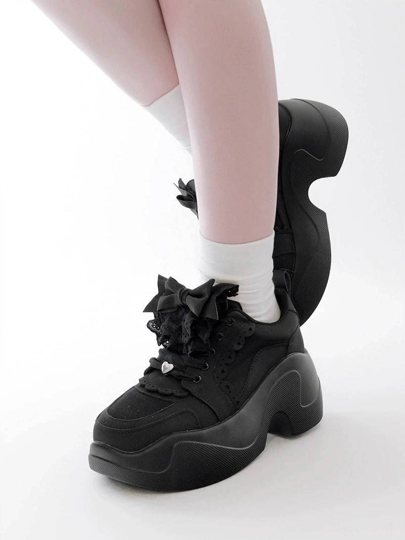 Black Jirai Kei platform sneakers low rear-side foot view all-black design chunky platform tongue bow decoration studio white background