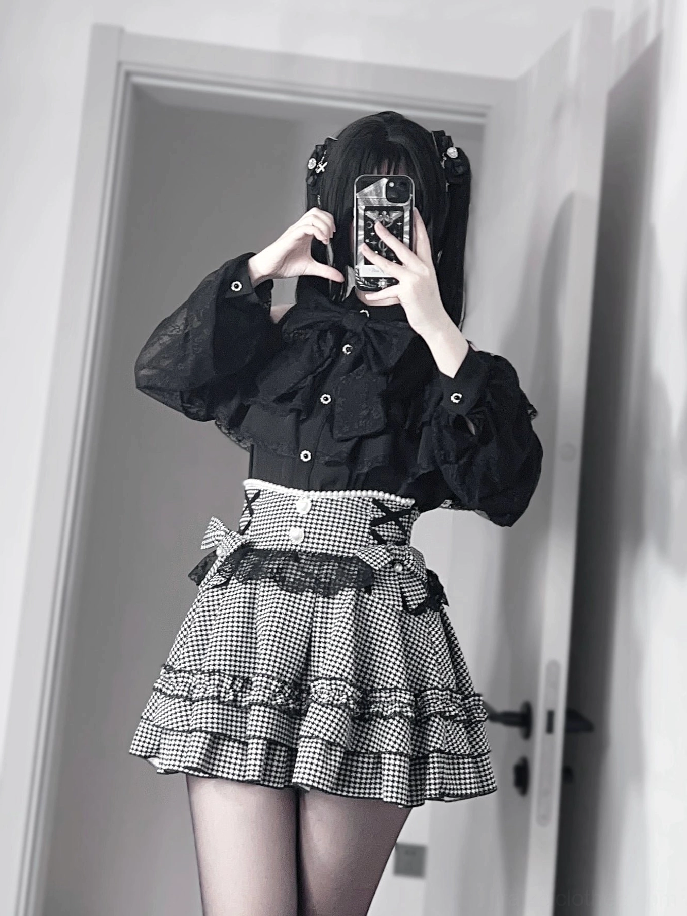 Black jirai kei high-waisted ruffle skirt close-up front view highlighting buttoned waist trim, heart-shaped buttons, and layered ruffled hem details