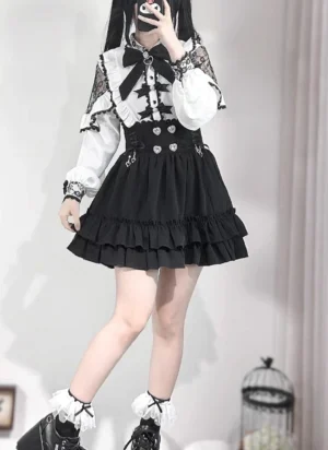Gothic Jirai Kei black skirt with heart rhinestone decorations and high-waisted silhouette, worn with platform leather shoes, displayed in mirror selfie oblique side view showing ruffle hem layers