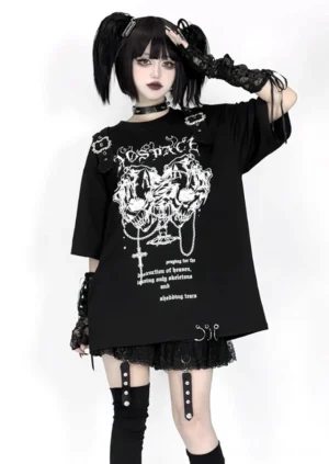 Black oversized skull graphic jirai kei top three quarter angle view goth model with ponytails lace accessories and leg straps