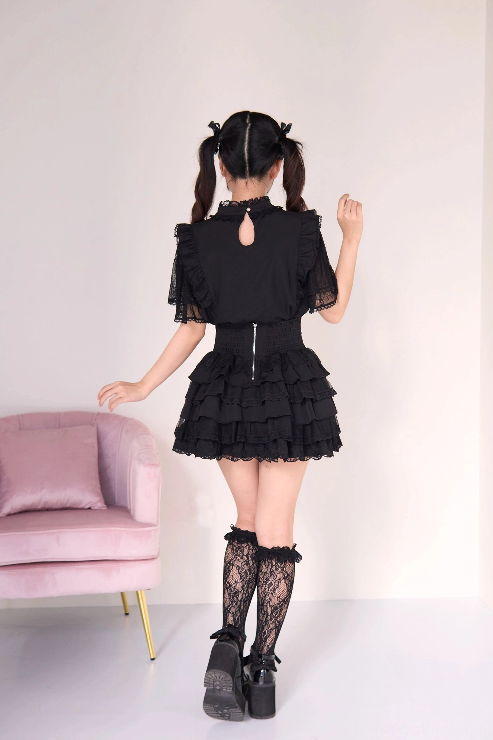 Black jirai kei tiered cake skirt with gothic lolita blouse back view, showing keyhole cutout back zipper closure and dramatic layered ruffle skirt with fishnet stockings