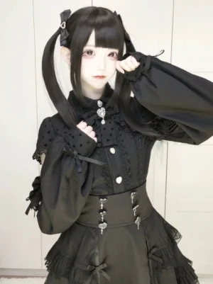 Black Jirai Kei high-waist tiered skirt with mesh layers front view on model with twin-tails wearing cold-shoulder top with heart metal trims