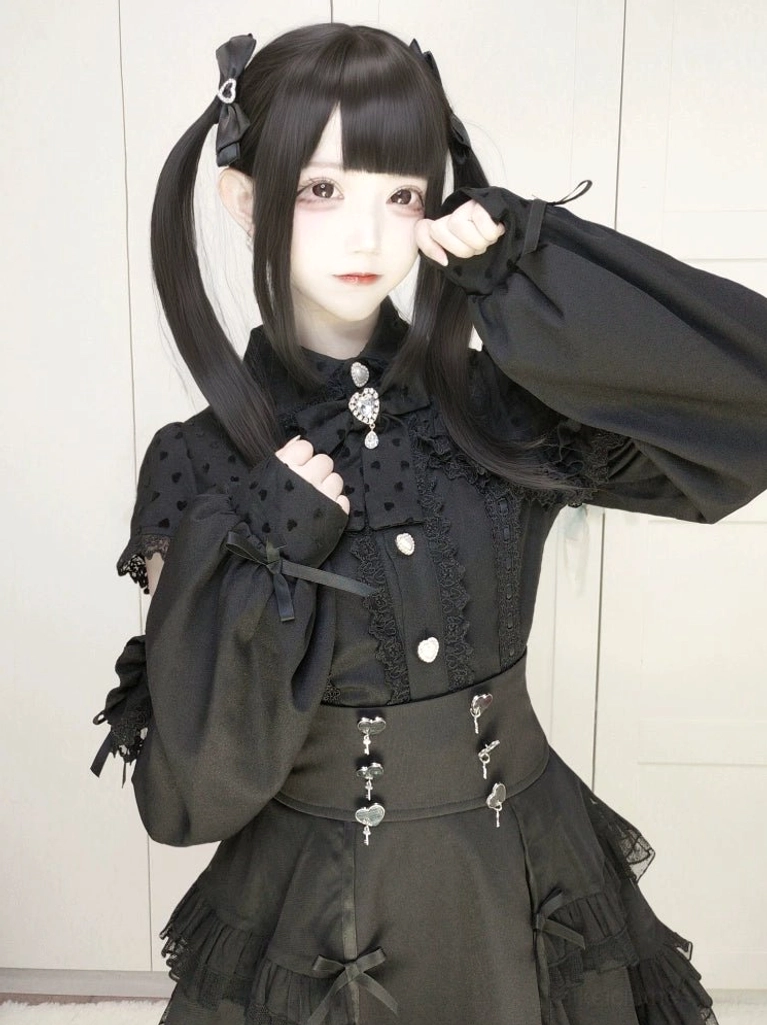 Black Jirai Kei high-waist tiered skirt with mesh layers front view on model with twin-tails wearing cold-shoulder top with heart metal trims