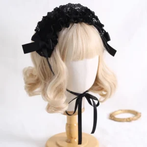 Black lace Jirai Kei bow headband with ruffled lace trim and coordinating satin side bows on mannequin with blonde curly wig, front three-quarter view showing intricate gothic lace details and adjustable neck ribbon