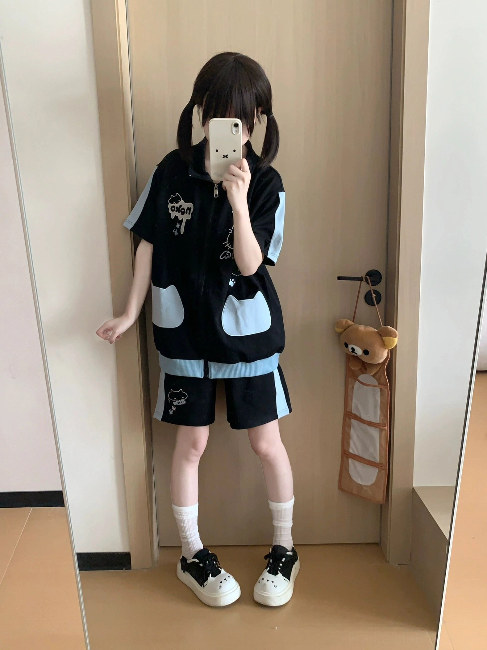 Black and light blue cat printed two-piece Jirai Kei casual outfit featuring cartoon kitten embroidery, modeled in indoor home cloakroom with twin-tailed styling